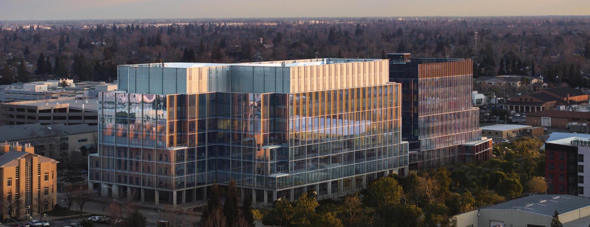 Building with glass windows surrounded by trees.