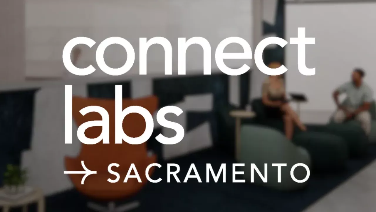 Darkened image of an office space with the words "Connect Labs - Sacramento" written in white lettering over it.