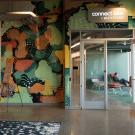 People mingle outside the entrance to office space that has a sign above it that reads "Connect Labs by Wexford".